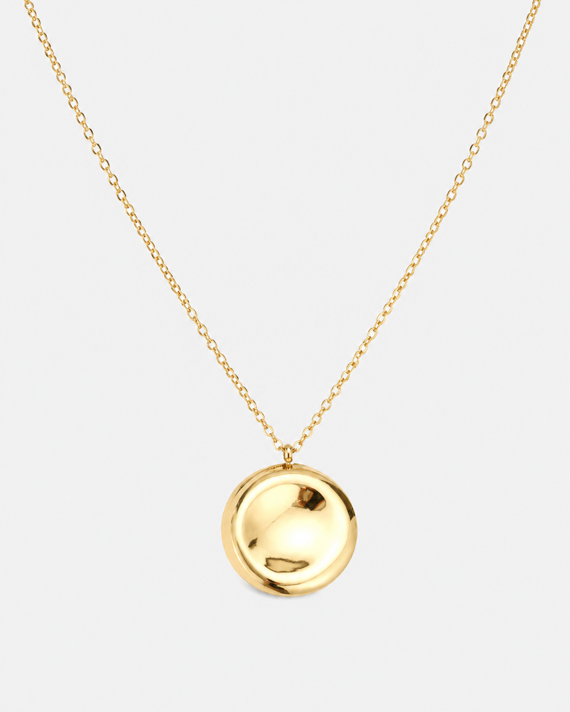 Goldene Halskette mit feiner Gliederkette und rundem, hochglänzendem Medaillon-Anhänger auf hellem Hintergrund.