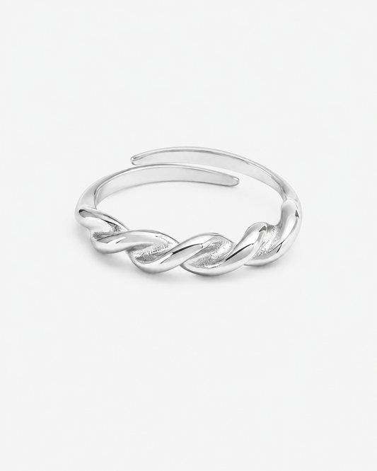 Silberfarbener Ring aus Edelstahl mit gedrehtem Twist-Design auf hellem Hintergrund.
