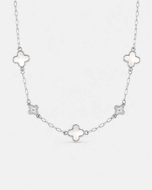 Silberfarbene Halskette aus Edelstahl mit drei Kleeblatt-Anhängern in Perlmutt-Optik und zwei filigranen Blumen-Elementen an einer feinen Gliederkette.