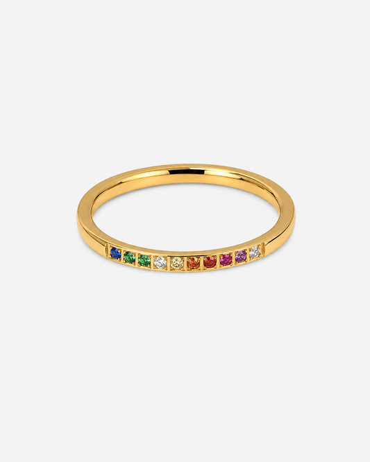     Feiner goldfarbener Ring mit kleinen bunten Steinen in Rainbow-Optik vor hellem Hintergrund.