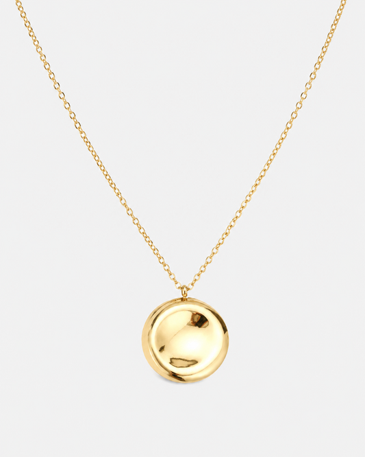 Goldene Halskette mit feiner Gliederkette und rundem, hochglänzendem Medaillon-Anhänger auf hellem Hintergrund.