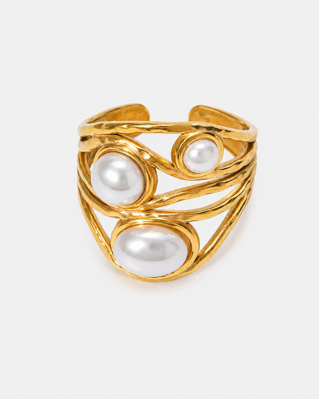 Goldfarbener Chunky Statement Ring aus Edelstahl mit 18 Karat Vergoldung, organischem mehrlagigem Design und drei weißen Perlen auf hellem neutralem Hintergrund.