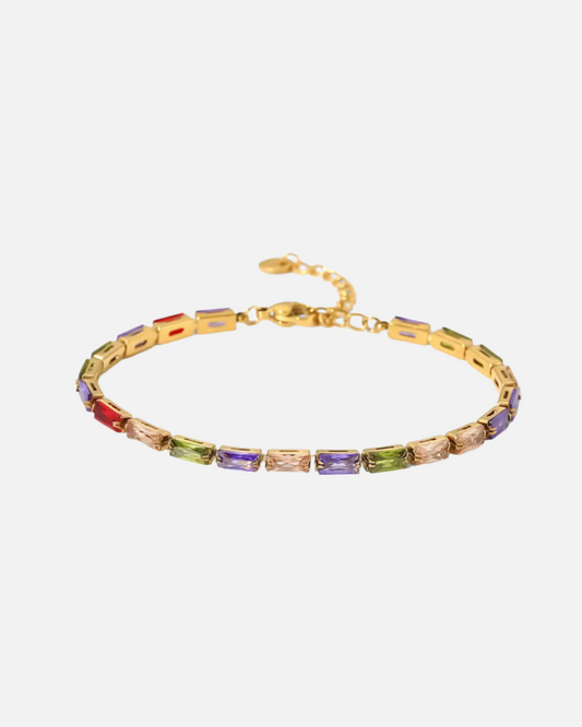 Vergoldetes Edelstahl Armband mit bunten rechteckigen Zirkonia-Steinen auf hellem Hintergrund.