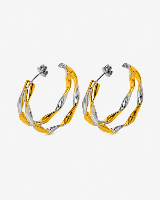 Bicolor Creolen aus Edelstahl in Silber und Gold mit gedrehter organischer Form und glänzender Oberfläche.