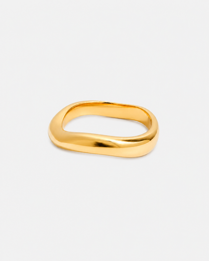 Vergoldeter Edelstahl-Ring mit weicher, organischer Silhouette und glänzender Oberfläche auf hellem Hintergrund.